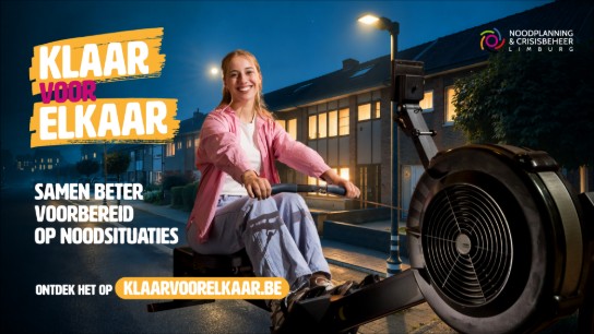 Vrouw die lacht en roeit op roeimachine in straat, campagne voor noodplanning Limburg. (vergroot foto)